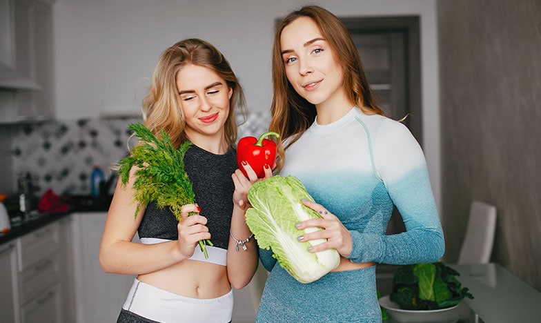 Две жени с детоксикиращи зеленчуци